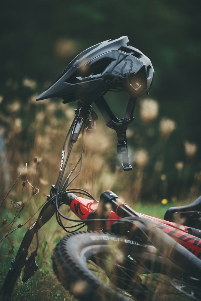 black-and-red-bicycle-helmet-on-brown-grass-during-daytime-l-48zzf9bco