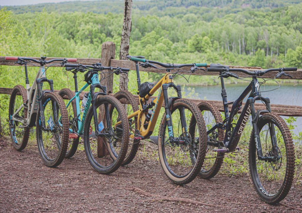 Mountain Bikes Leaning on a Wooden Fence overlooking lake and trees